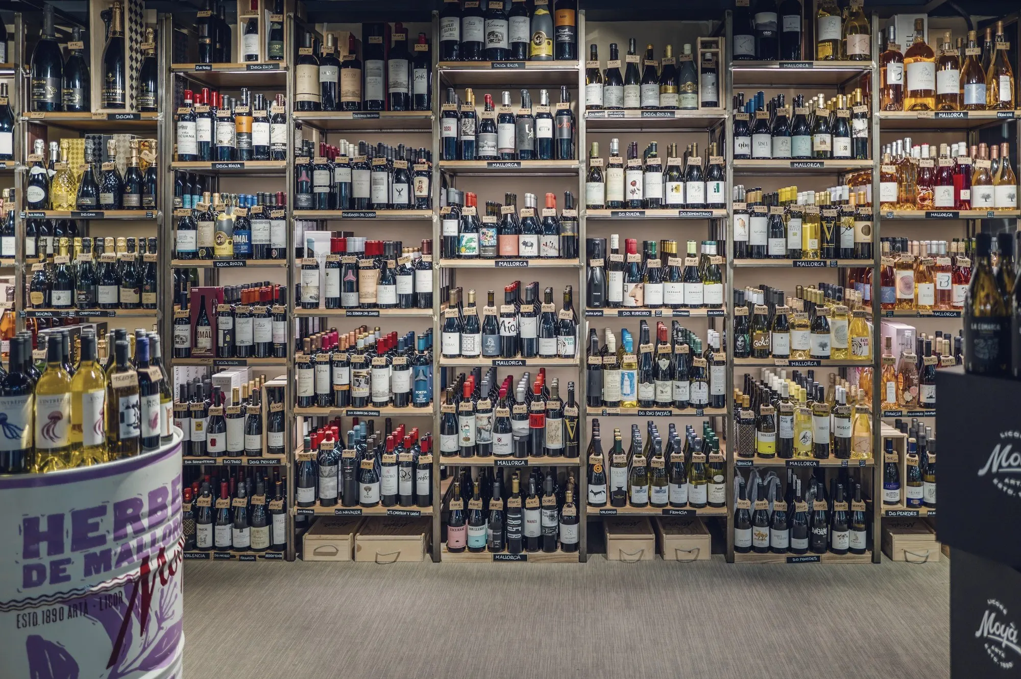 Floor-to-ceiling shelves of wine and spirits bottles inside a well-stocked liquor store.