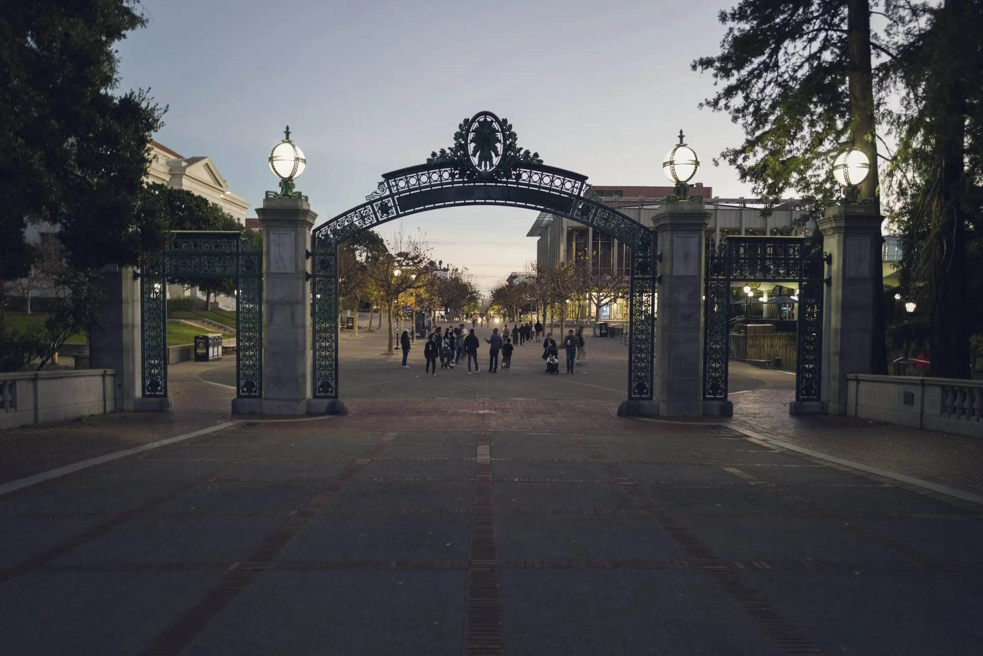 Students walking through Sather Gate at UC Berkeley at dusk