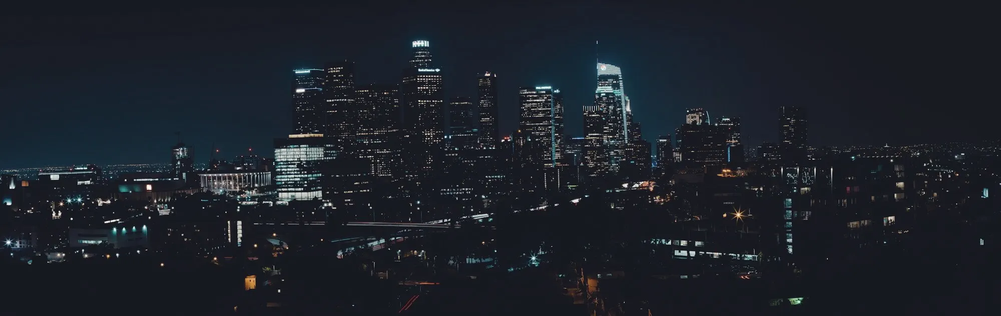 The downtown Los Angeles skyline lit up against a dark night sky.