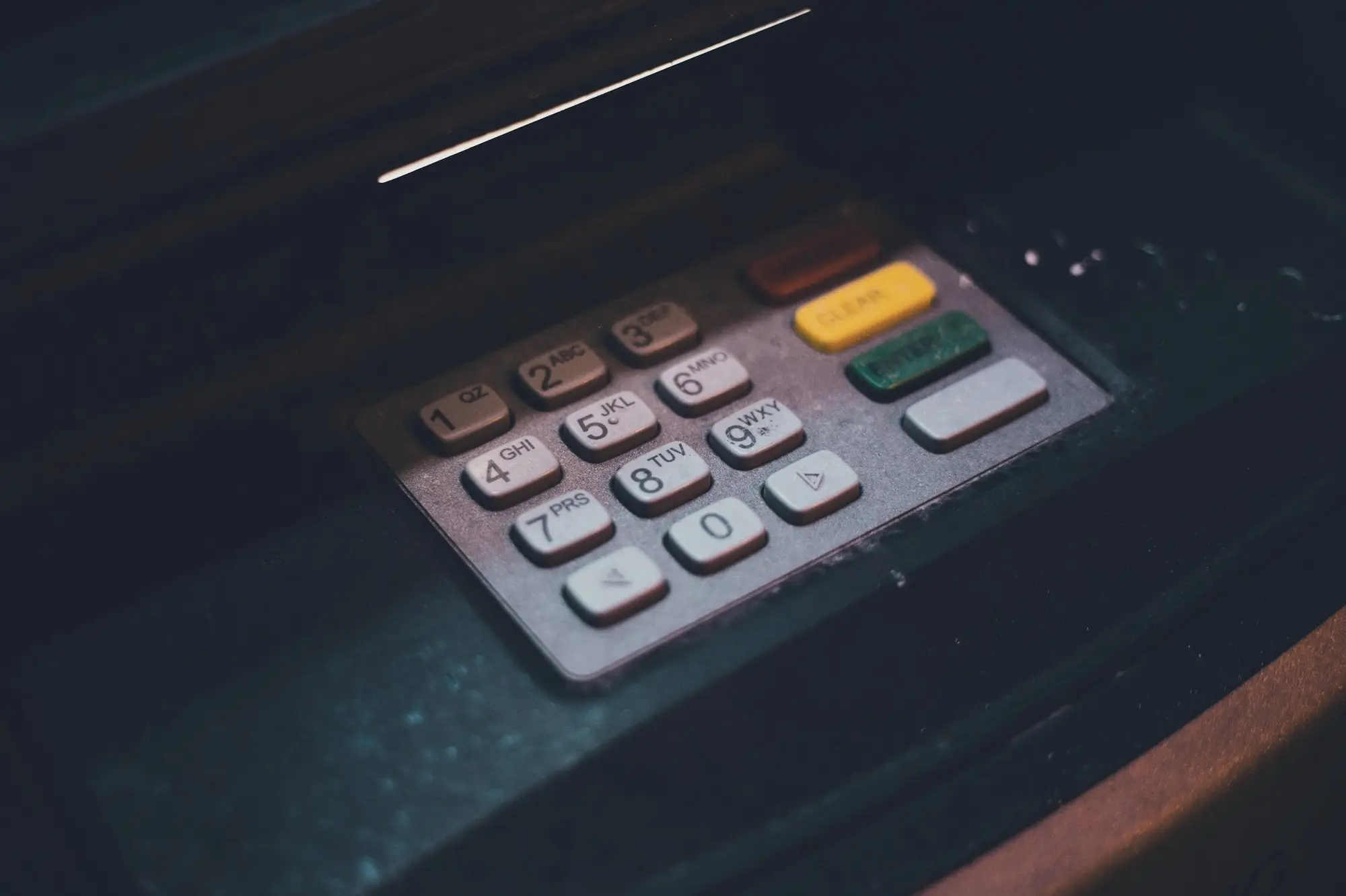 Close-up of an ATM keypad in low light.