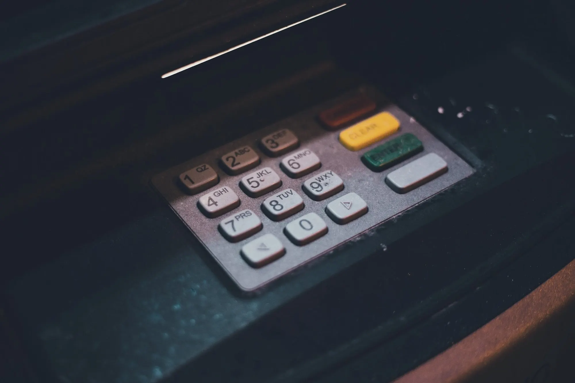 Close-up of an ATM keypad in low light.