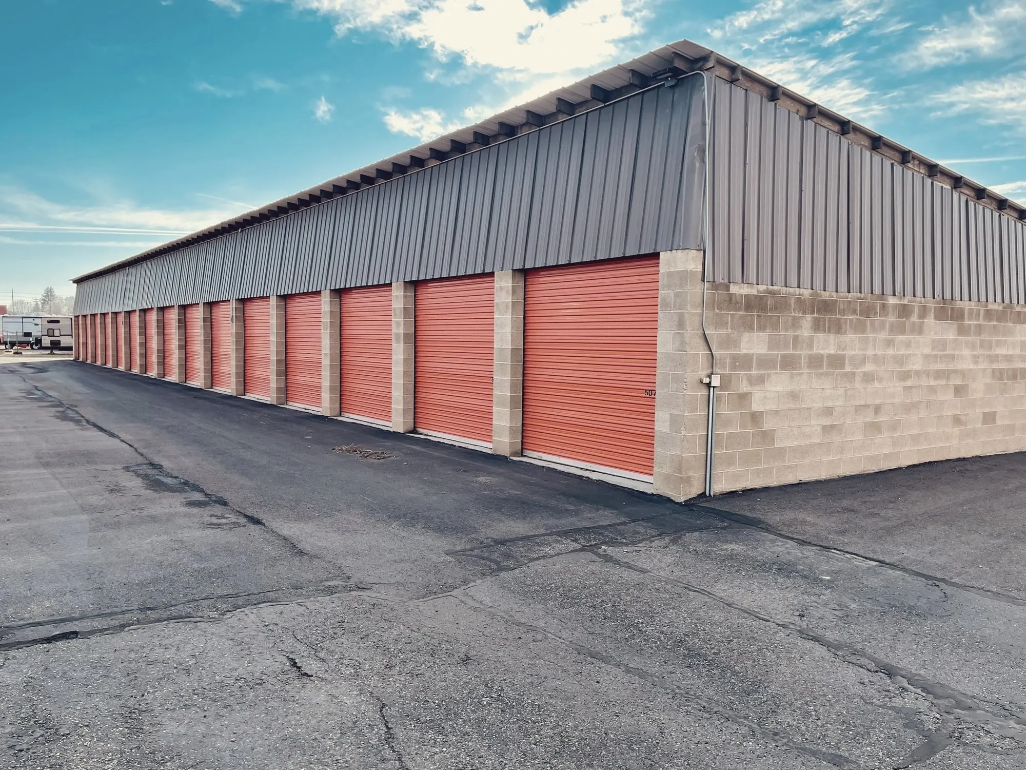 A row of orange roll-up doors at a self-storage facility.